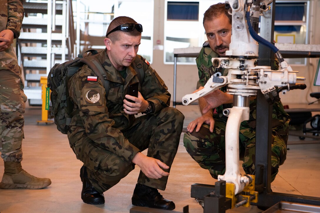 Polish Air Force Capt. Arkadiusz Kluba, discusses Portuguese F-16 operations with a Portuguese Air Force Master Sgt., during the European Partnership Flight at Monte Real Air Base, Portugal, Sept. 10, 2019. The European Partnership Flight serves as an opportunity for the U.S. and partner nations to share best practices, strengthen relationships, and build trust. (U.S. Army photo by Specialist Catessa Palone)