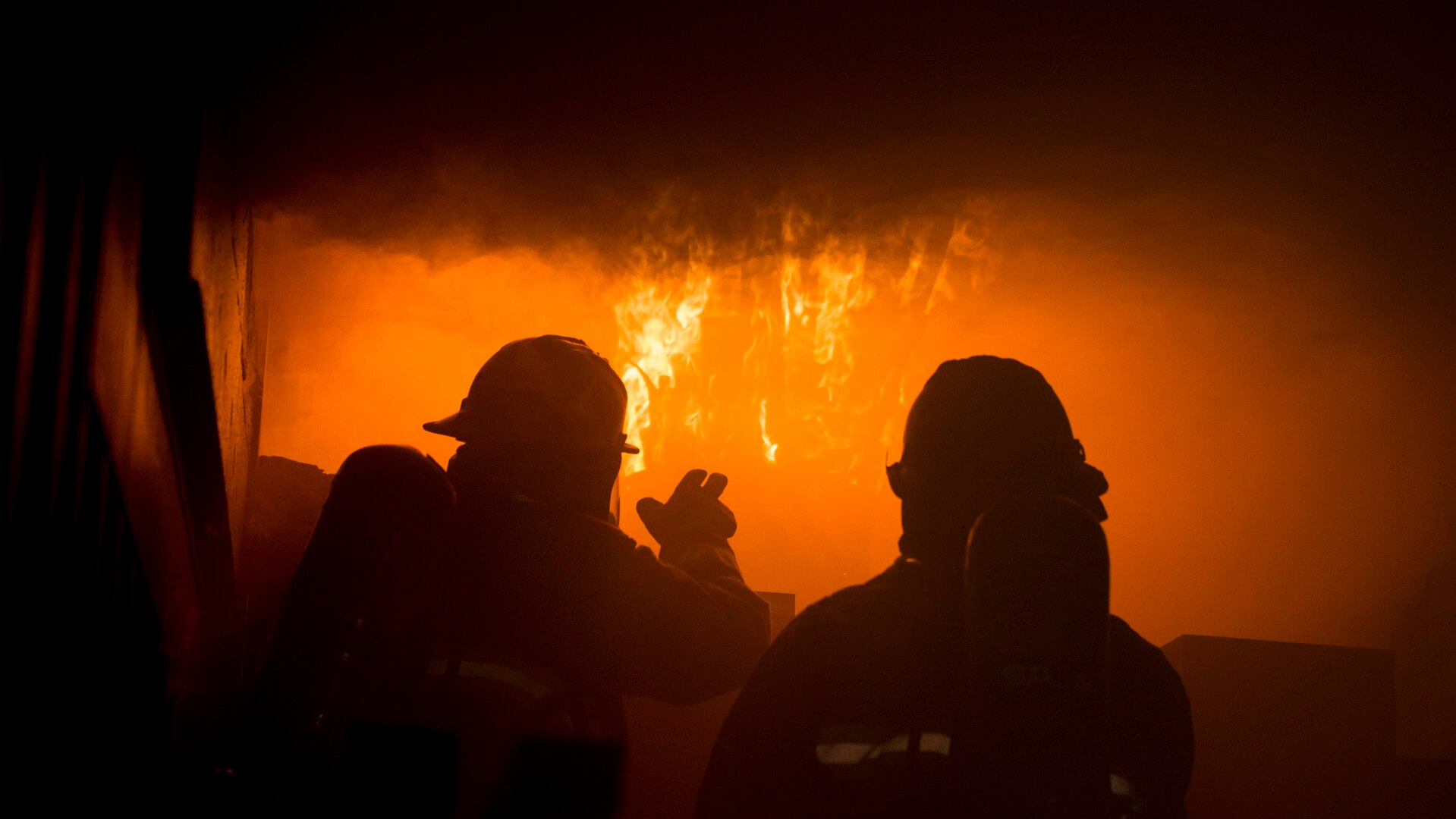 Staff Sgt. Jack Simonds, a firefighter with the Gowen Field Fire Department, instructs a fellow Gowen Field firefighter how to recognize the signs of flashover during training in a specialized mobile burn trailer, Gowen Field, Boise, Idaho, Sept. 13, 2019.