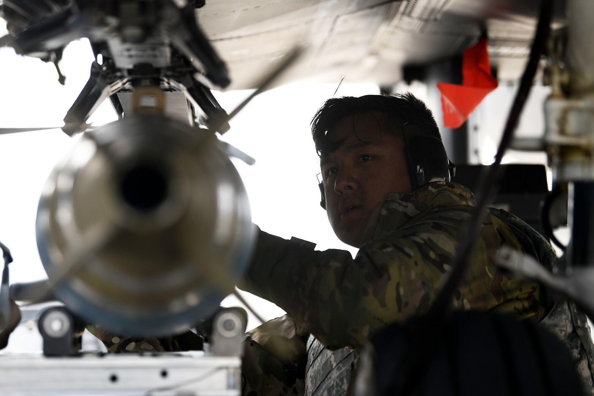 A 48th Munitions Squadron weapons standardization load crew airman affixes munition onto an F-15E Strike Eagle during a Forward Arming and Refueling Point exercise at Royal Air Force Mildenhall, England, Sept. 12, 2019. Liberty Wing Airmen had the opportunity to execute unloading an MC-130J Commando at the FARP point, bomb-build on-site and re-arm participating Strike Eagles.  (U.S. Air Force photo by Airman 1st Class Shanice Williams-Jones)
