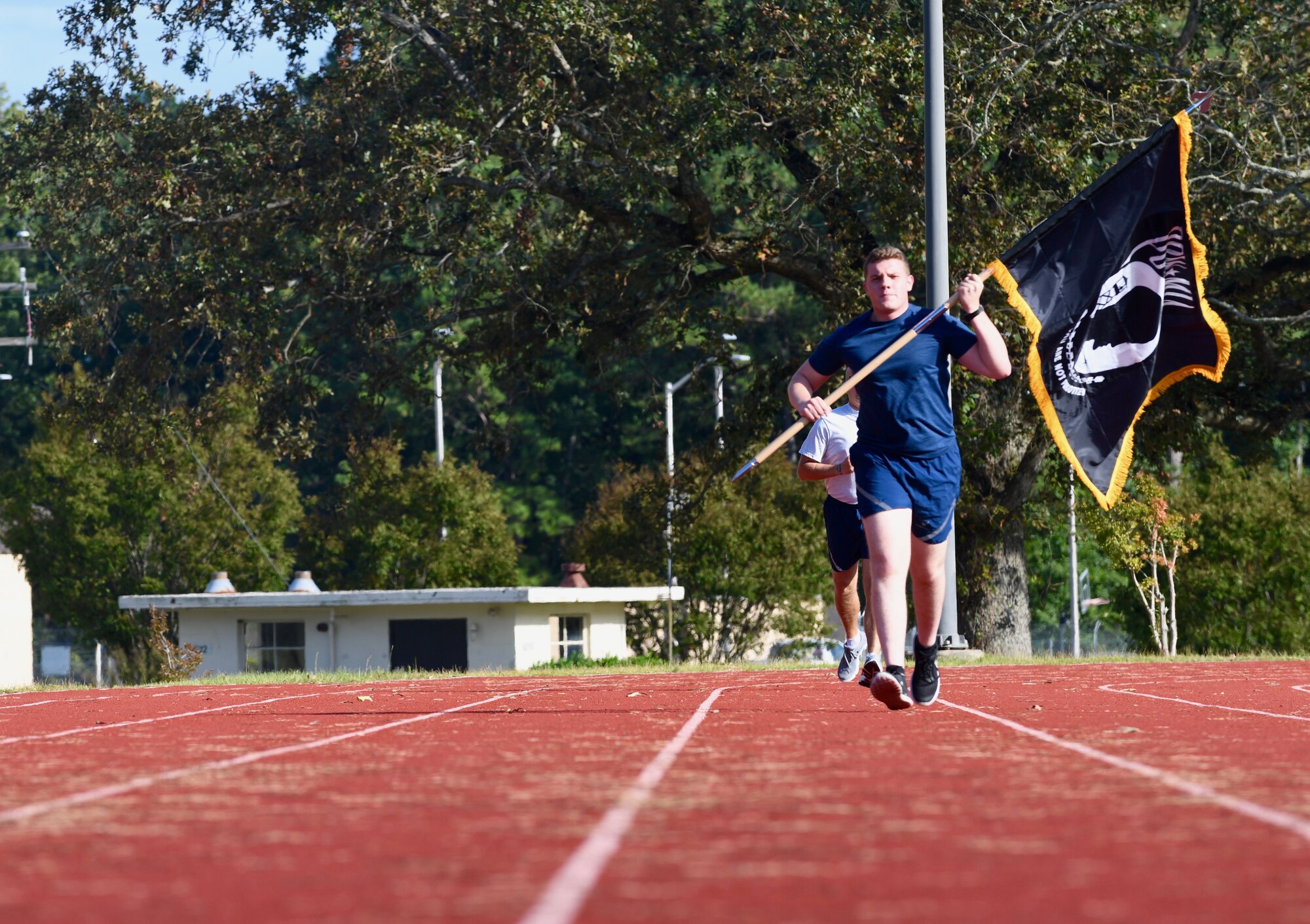 Amn Robert New, 4th Security Force Squadron defender, carries the POW/MIA flag during the 24 hour POW/MIA Recognition Day Marathon Sept. 18, 2019, at Seymour Johnson Air Force Base, North Carolina. During the event, members of the 4th Fighter Wing ran the POW/MIA flag around the track for an entire 24 hours to honor those who were designated prisoners of war or missing in action. (U.S. Air Force photo by Staff Sgt Michael Charles)