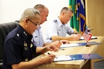 From left to right: Air Marshal Tarin Punsri, Royal Thai Air Force; Maj. Gen. Brian Killough, U.S. Air Force-Pacific Deputy Commander; and Brig. Gen. Jeremy Horn, assistant adjutant general, Washington Air National Guard, sign an agreement between units after the sixth Airmen-to-Airmen talks Aug. 28, 2019, at Camp Murray, Wash.