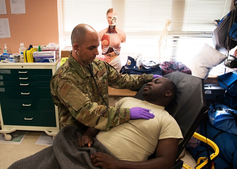 Tech Sgt. Simon Oliver, 459th Aeromedical Staging Squadron medical technician does training on Senior Airman Collin Owusu, 459th ASTS medical technician, Sept. 19, 2019, at Joint Base Andrews, Md. Oliver recently played a role in saving a passengers life while on a commercial flight to Jamaica. (U.S. Air Force photo by Staff Sgt. Cierra Presentado/Released)