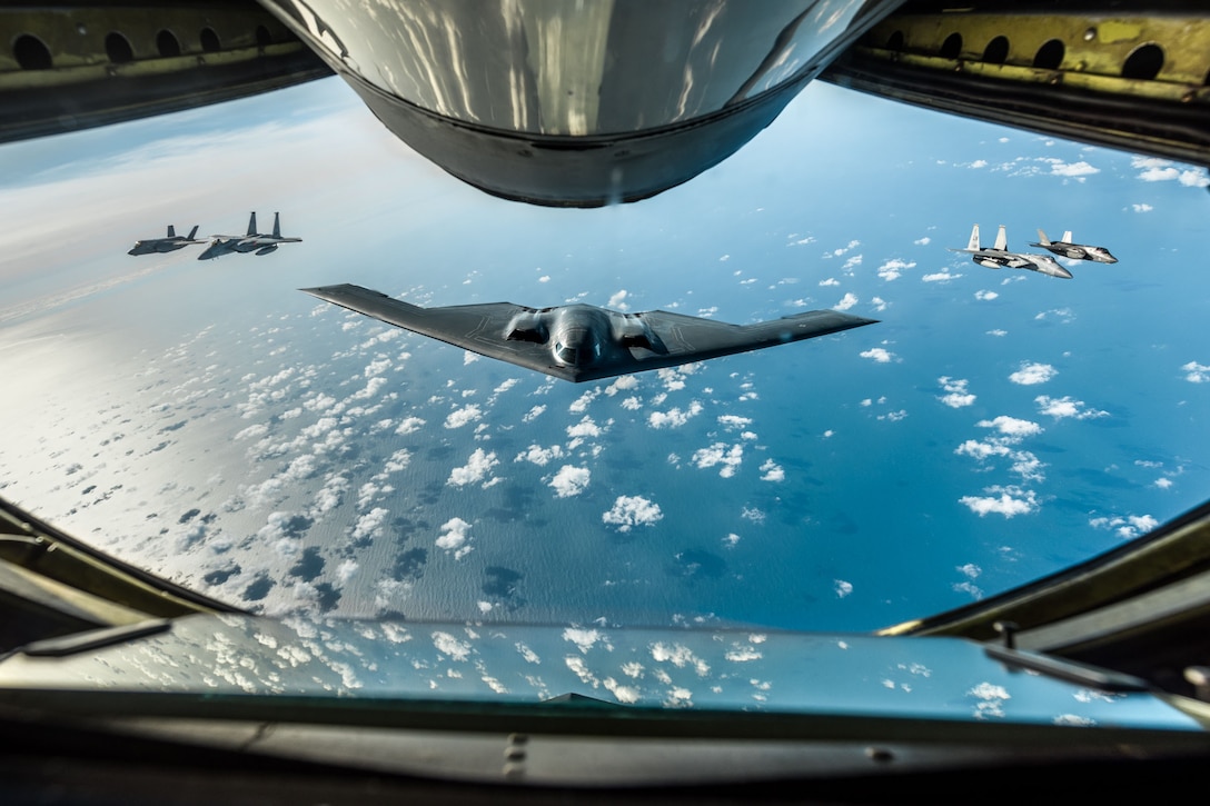 A group of military aircraft fly in formation.