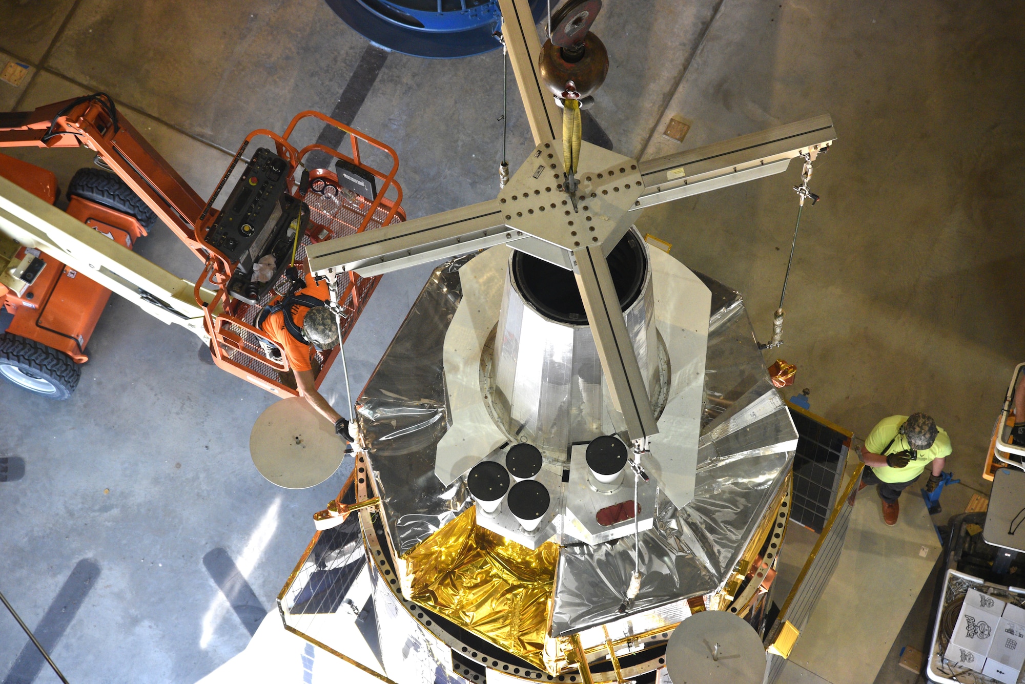 Photo of restoration crews moving a test satellite out of the missile gallery of the air force museum.