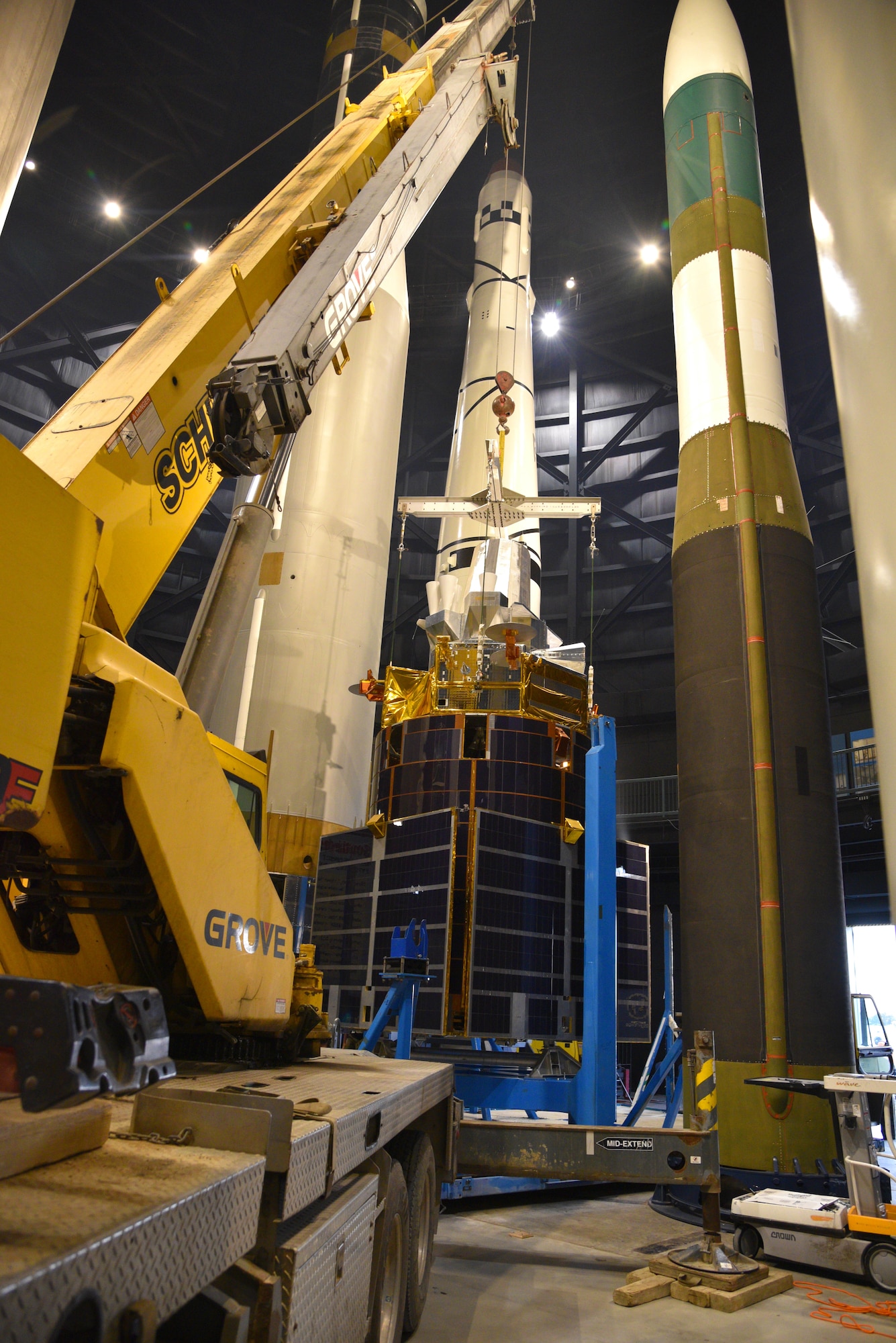 Photo of construction moving equipment and a test satellite in the missile gallery of the air force museum.