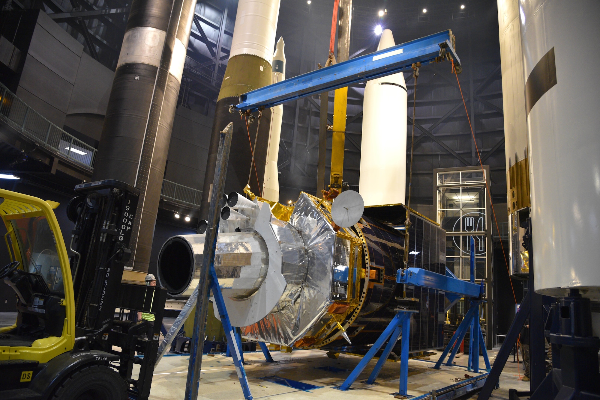 Photo of construction equipment and a test satellite.