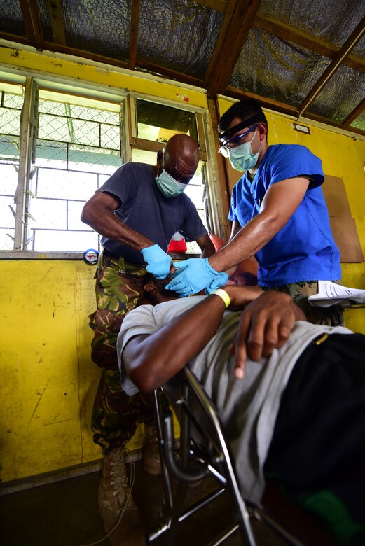 Papua New Guinea Defence Force Maj. Bais Gwale, a Pacific Angel 19-4 dentist, and U.S. Navy Petty Officer Victor Chiquete, a PAC Angel 19-4 dental technician, extract a patient’s tooth at a health services outreach site in Lae, Papua New Guinea Sept. 9, 2019. Pacific Angel is multinational humanitarian assistance civil military engagement, improving military-to-military partnerships in the Pacific through medical health outreach, civic engineering projects and subject matter expert exchanges between U.S. service members, multinational militaries, non-governmental organizations, and PNG military and civilian participants. (U.S. Air Force photo by Tech. Sgt. Jerilyn Quintanilla)