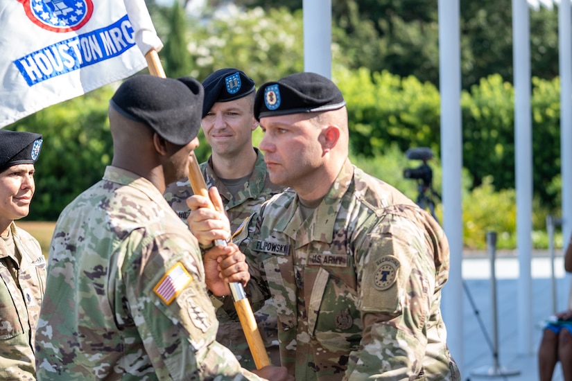 1st Sgt. Brian Filipowski, right, senior enlisted advisor, Houston Medical Recruiting Company, hands the company guidon to Capt. Ryan Sanders, left, outgoing commander, Houston MRC, during the company's change of command ceremony at Hermann Park Conservancy, Houston, Texas, Sept. 5.