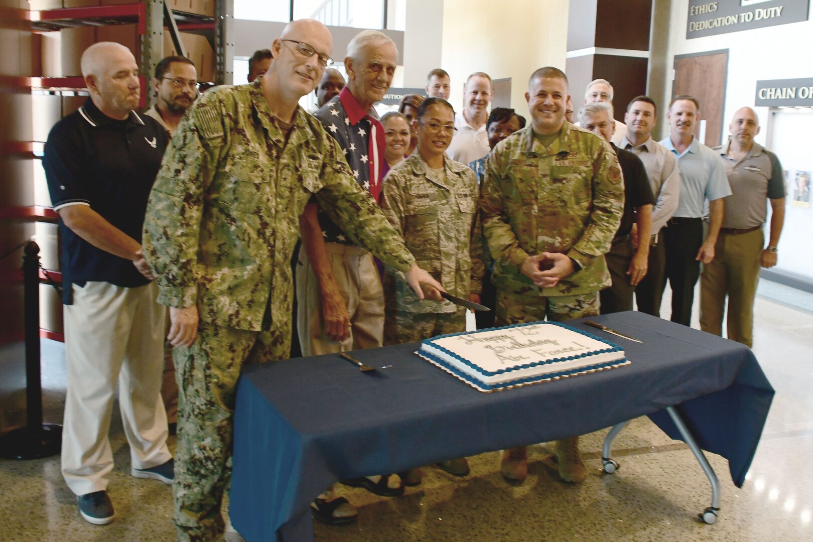 A group of people gathered around a cake celebrating the 72nd anniversary of the Air Force.