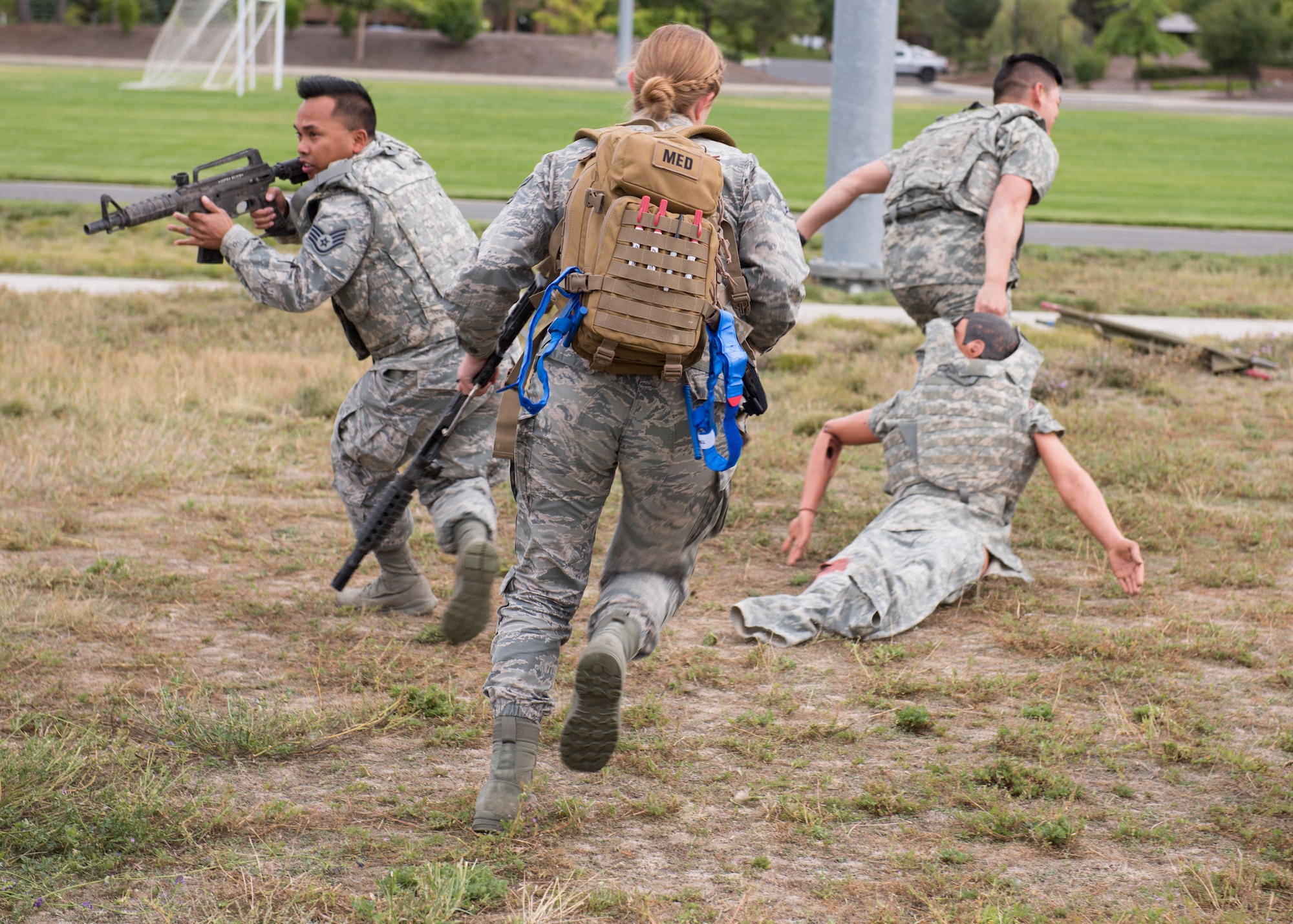 U.S. Air Force students provide cover while pulling a ‘wounded’ training mannequin out of the simulated line-of-fire during the Tactical Combat Casualty Care course at Fairchild Air Force Base, Washington, Sept. 12, 2019. Battlefield simulation drills are vital to provide medics and combat personnel with realistic situations where they provide life-saving care and evacuation of wounded. (U.S. Air Force photo by Senior Airman Ryan Lackey)