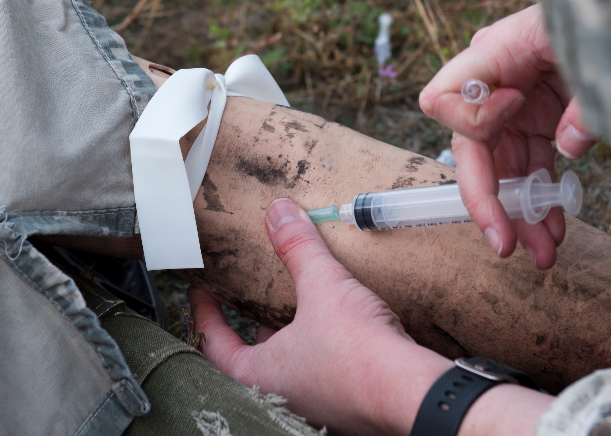 A student provides an injection to a ‘wounded’ training mannequin during the Tactical Combat Casualty Care course at Fairchild Air Force Base, Washington, Sept. 12, 2019. TCCC is designed to help lessen preventable combat deaths by providing proven trauma stabilization techniques, allowing for wounded to survive long enough to receive life-saving treatment. (U.S. Air Force photo by Senior Airman Ryan Lackey)