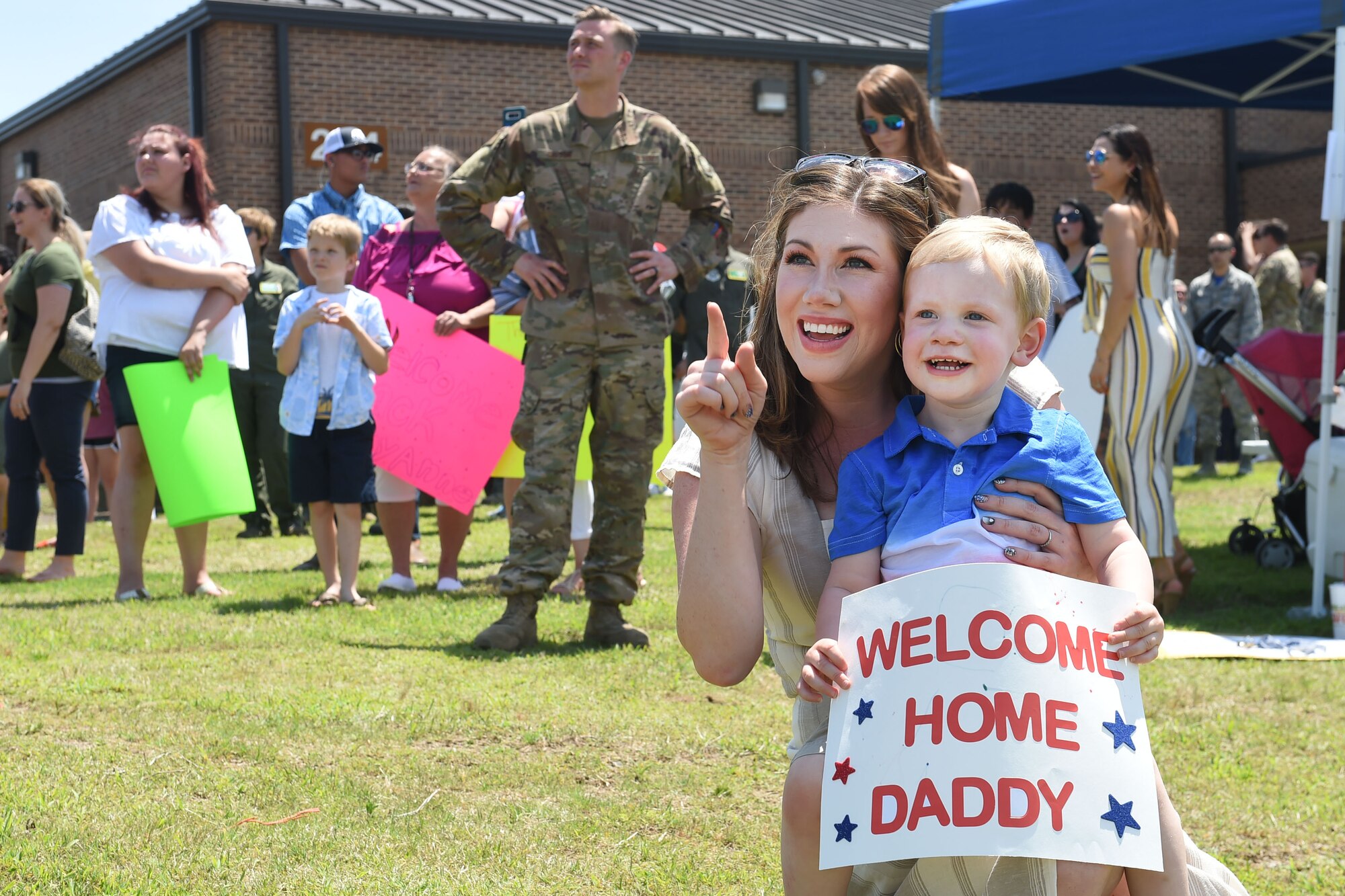 A mother and her son await the return of an Airman.