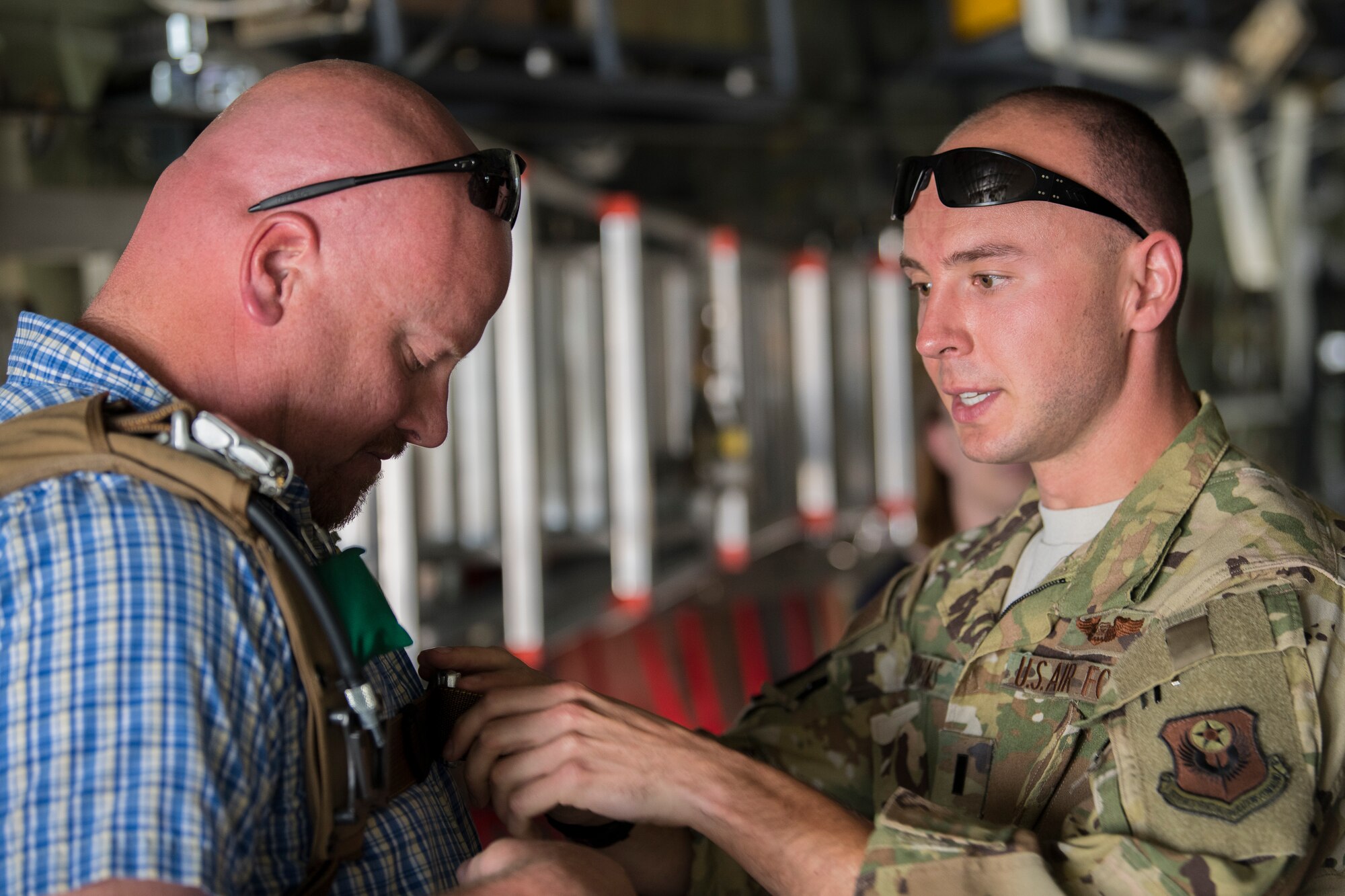 1st Lt. John Burns, 16th Special Operations Squadron combat systems operator, instructs Phillip Lemke, Gattis Middle School assistant principal, on how to wear a parachute during Teachers Understanding Deployment Operations at Cannon Air Force Base, N.M, Sept. 14, 2019. TUDOS is a program made to educate teachers and faculty of local schools about what military life is like and how it can affect the children of military members. (U.S. Air Force photo by Senior Airman Vernon R. Walter III)