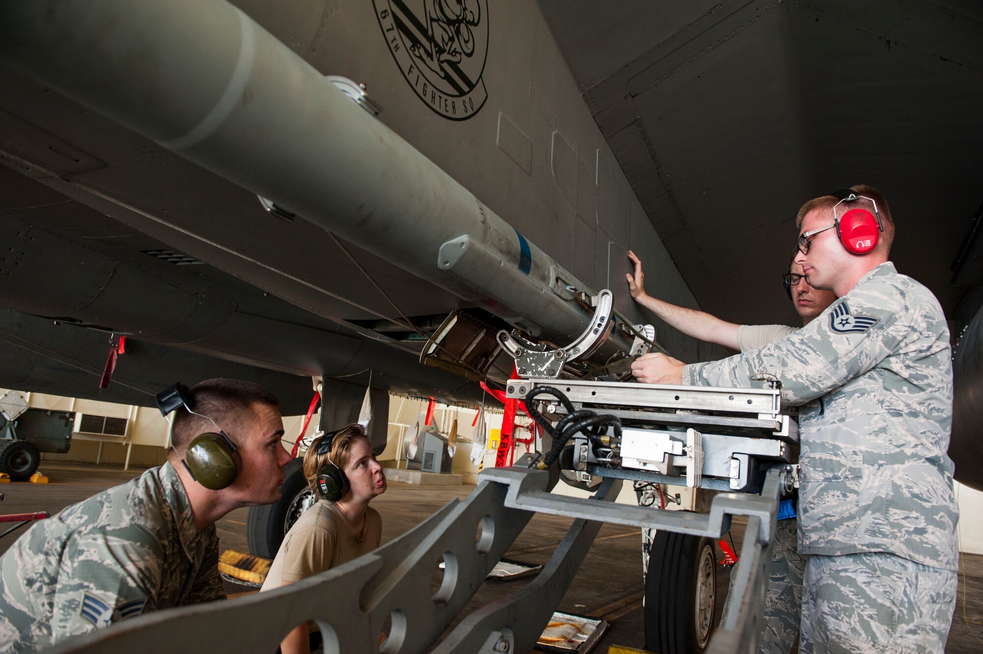 U.S. Air Force Airman Staff Sgt. Marcus Brun (right), 18th Aircraft Maintenance Squadron weapons lead crew chief, instructs 44th Aircraft Maintenance Unit weapons load crew members during initial certification training at Kadena Air Base, Japan, Sept. 11, 2019. The 18th Maintenance Group is composed of six squadrons and maintains combat-ready aircraft to support air operations directed by the Pacific Air Forces commander. (U.S. Air Force photo by Naoto Anazawa)