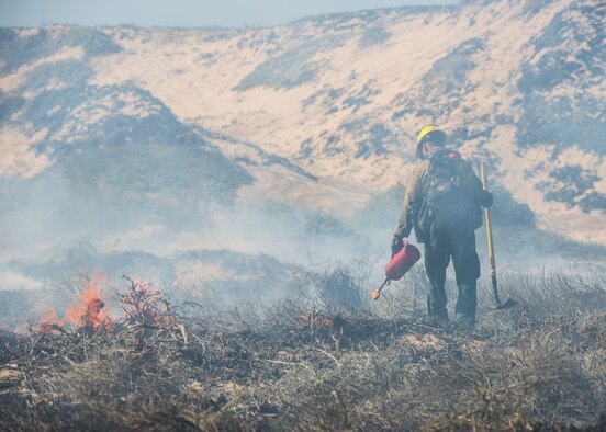 A member of Vandenberg Hotshots subdues a controlled fire Sept. 18, 2019 at Vandenberg Air Force Base, Calif. The goal of this one-day burn was to reduce the risk of wildfires, as well as increase the habitat for an endangered species that resides in the area by re-contouring the sand dunes for more suitable nesting conditions. (U.S. Air Force photo by Airman 1st Class Aubree Milks)