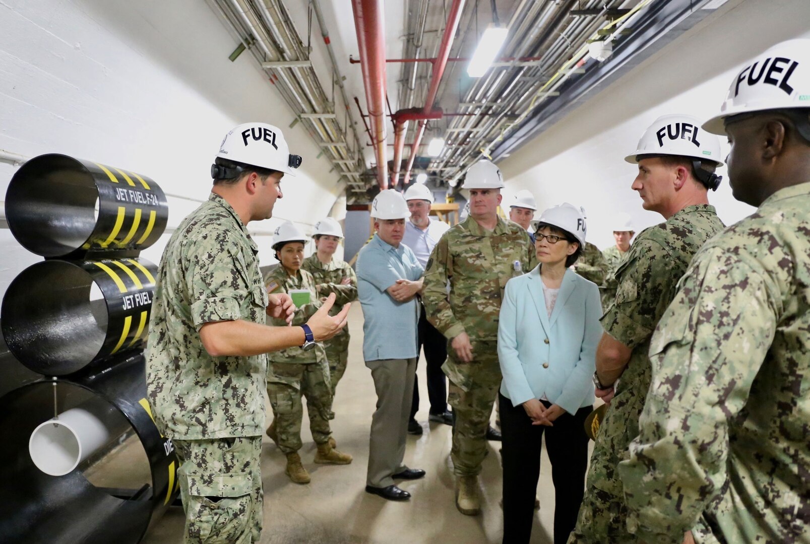 A group of people tour an underground fuel storage facility.
