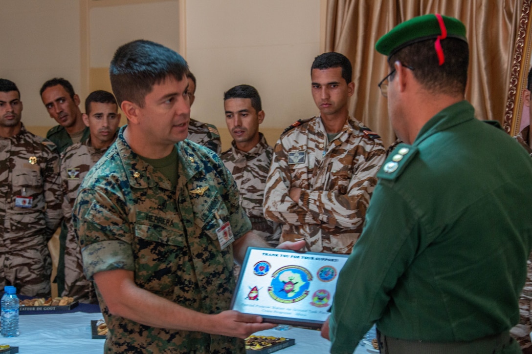 A U.S. Marine with Special Purpose Marine Air-Ground Task Force-Crisis Response-Africa 19.2, Marine Forces Europe and Africa, presents a certificate of appreciation to a member of the Royal Moroccan Armed Forces following a tactical recovery of aircraft and personnel exercise, Sept. 11, 2019, in Tifnit, Morocco. TRAP is a core function of a crisis-response force and SPMAGTF-CR-AF 19.2 consistently trains to increase TRAP proficiency by rehearsing realistic scenarios. SPMAGTF-CR-AF is deployed to conduct crisis-response and theater-security operations in Africa and promote regional stability by conducting military-to-military training exercises throughout Europe and Africa. (U.S. Marine Corps photo by Capt. Clay Groover)