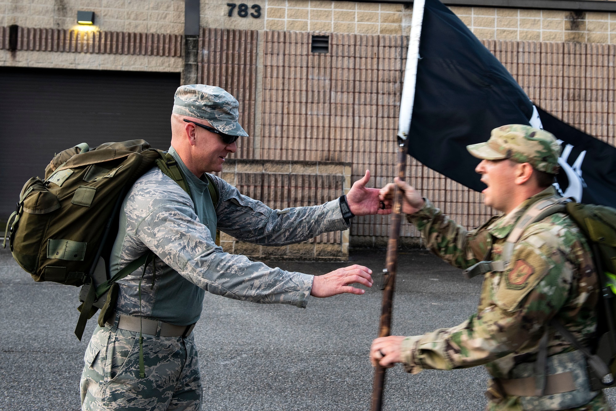 Staff Sgt. Scott Bobeck, left, 23d Maintenance Squadron fuel systems NCO in charge of training, receives the POW/MIA flag from Tech. Sgt. Cody Peterson, 476th Fighter Group occupational safety technician, during the POW/MIA Recognition Day ruck march Sept. 20, 2019, at Moody Air Force Base, Ga. In 1979, the United States Congress passed a resolution authorizing National POW/MIA Recognition Day to be observed together with the national effort of bringing isolated personnel home. The 347th Operations Support Squadron hosted the 24-hour ruck march to pay tribute to those who’ve been captured or missing in the line of duty. (U.S. Air Force photo by Senior Airman Erick Requadt)