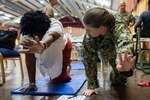 A physical therapist teaches stretching exercises to a Grenadian woman