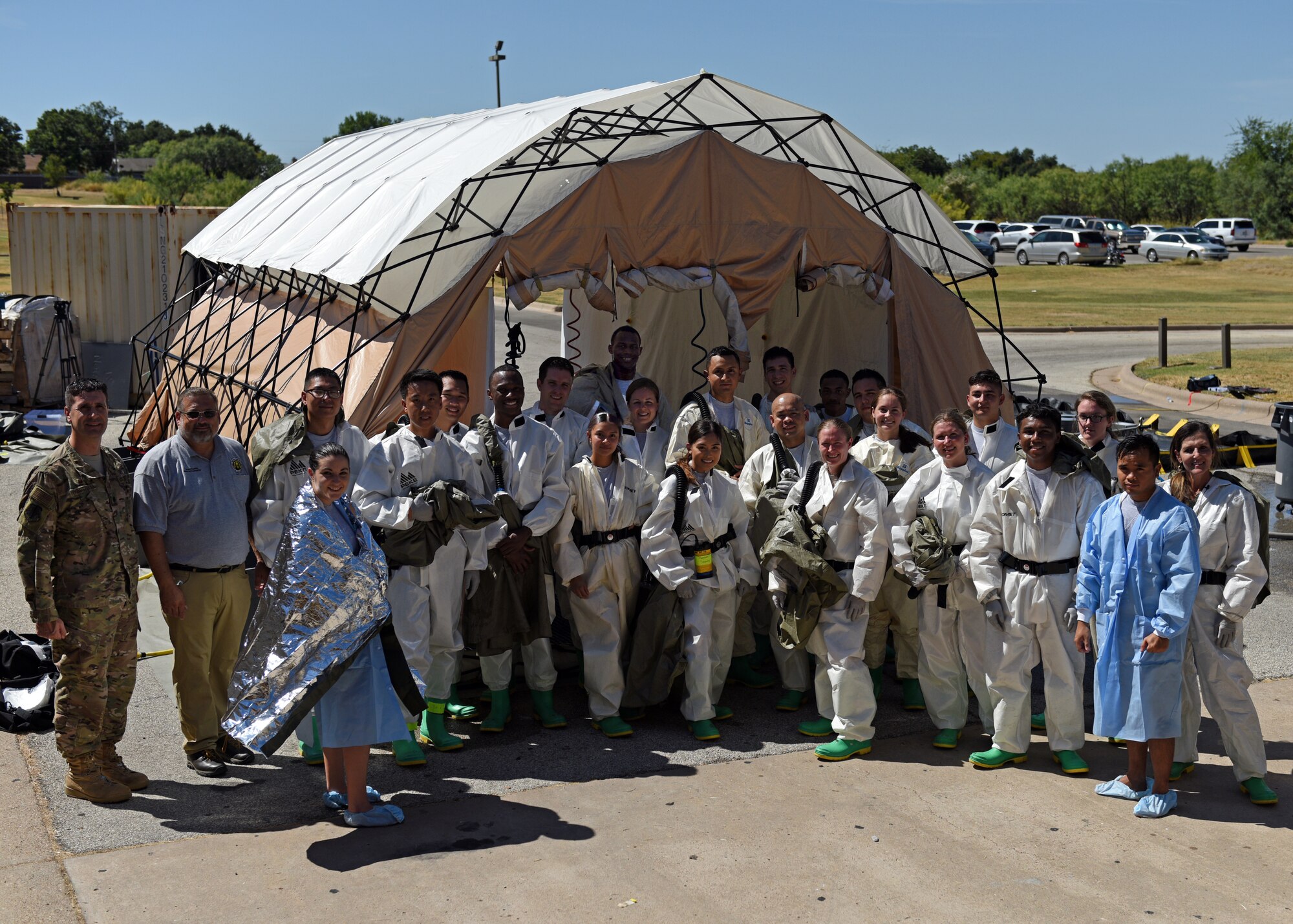 Personnel from the 17th Medical Group stand outside of the decontamination center during their medical in-place decontamination training at the Ross Clinic on Goodfellow Air Force Base, Texas, September 12, 2019. This training is to prepare medical personnel to handle decontaminations in emergency situations. (U.S. Air Force photo by Airman 1st Class Robyn Hunsinger/Released)