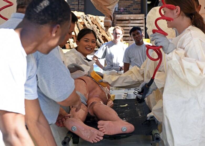 Personnel from the 17th Medical Group simulate decontamination of a patient during their medical in-place decontamination training at the Ross Clinic on Goodfellow Air Force Base, Texas, September 12, 2019. The suits that medical personnel wear during these events allow them to work in environments where they can cleanse patients of things such as radiation, chemicals, nerve agents, blister agents, and choking agents. (U.S. Air Force photo by Airman 1st Class Robyn Hunsinger/Released)