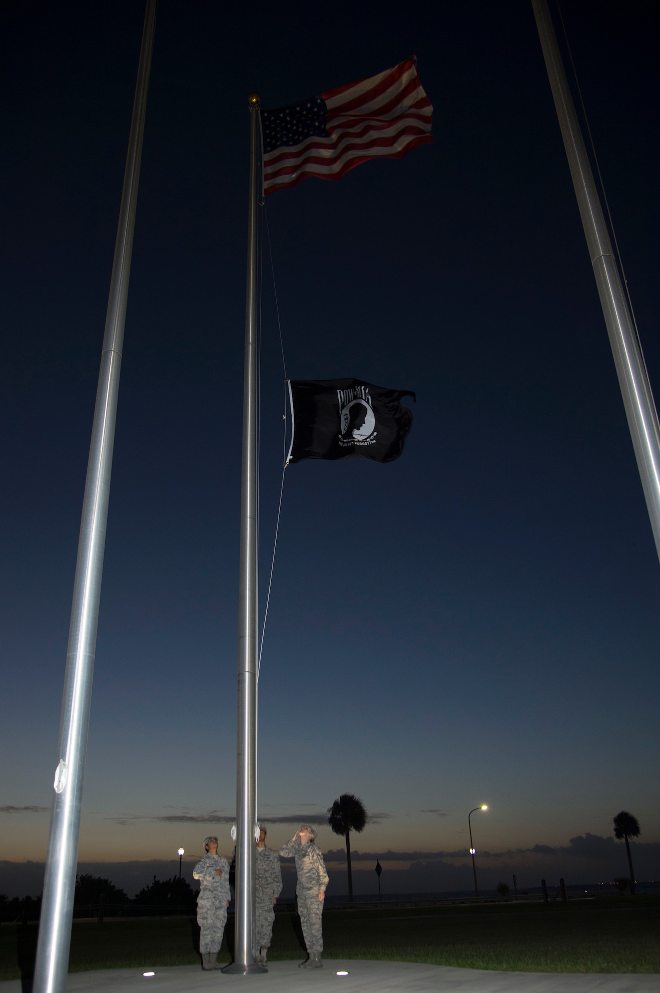 U.S. Air Force Senior Airman Karina Rodriguez (left), Airman 1st Class Dyllan Hipol (center), and Senior Airman Andrea Stutts (right), MacDill Air Force Base honor guardsmen, raise the POW/ MIA Flag Sept. 20, 2019, at MacDill AFB, Fla.  POW/MIA Recognition Day is commemorated nationally on the third Friday of every September in honor of service members who were prisoners of war as well as those missing in action. (U.S. Air Force photo by Airman 1st Class Shannon Bowman)