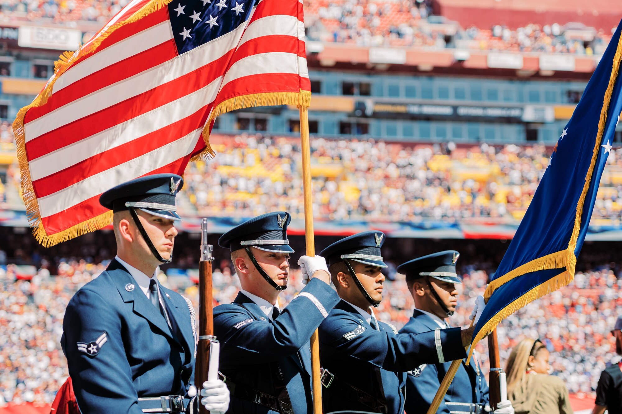 The United States Air Force Honor Guard presents the colors at a football game
