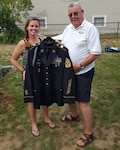 Sergeant 1st Class Jessica Biggins presents her grandfather Clifford Benoit with an Army Service Uniform (ASU) jacket representing his 33 years in service. Benoit is a veteran of the Korean War, during which he was a POW for three years.