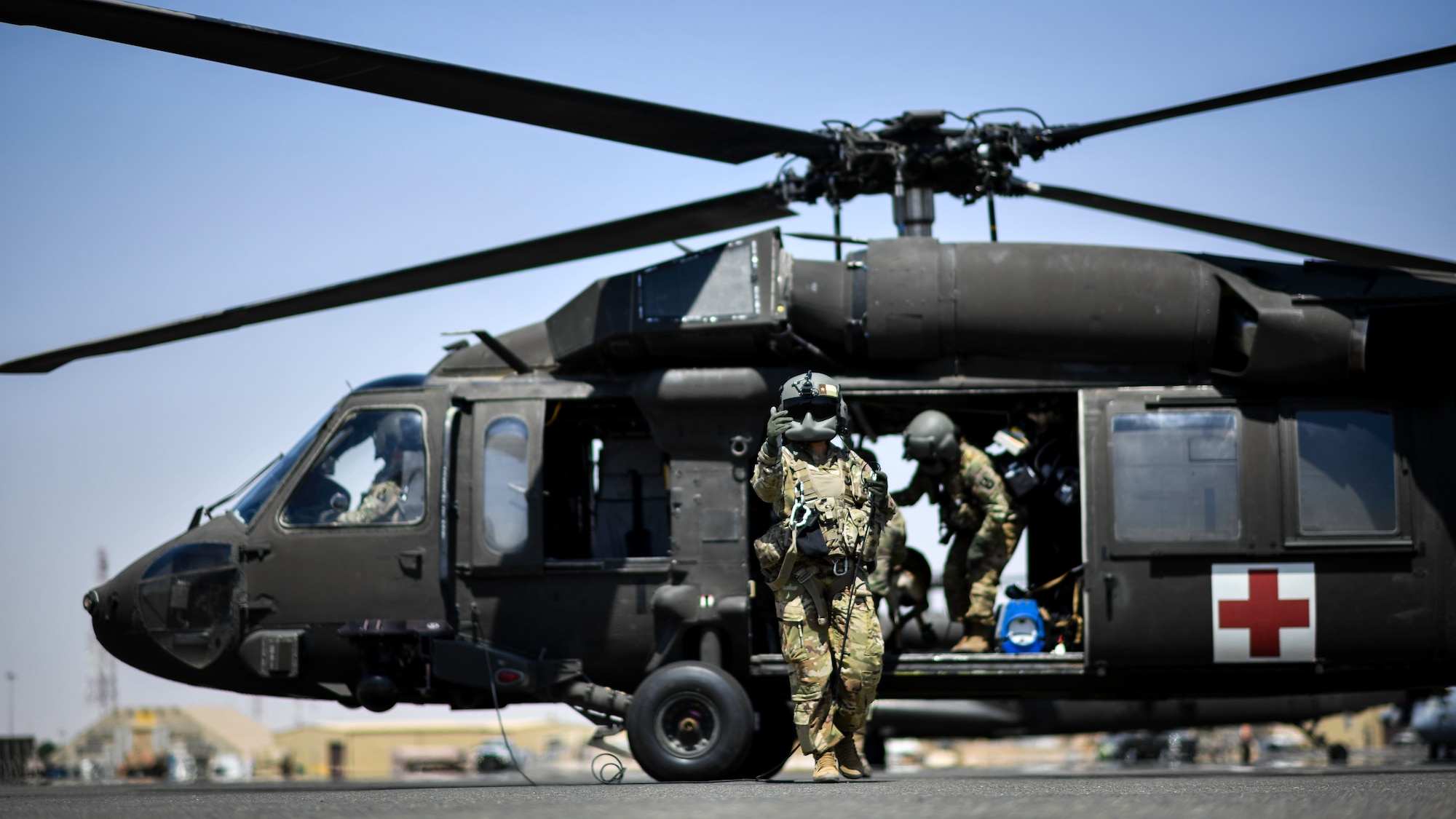 A UH-60 Black Hawk crewmember signals a military working dog team to board the aircraft at Ali Al Salem Air Base, Kuwait, Sept. 13, 2019. As part of the exercise, U.S. Army veterinary doctors worked together with emergency medical responders sharing life-saving measures for MWDs in case of extreme emergencies where veterinary technicians might not be immediately available. (U.S. Air Force photo by Staff Sgt. Mozer O. Da Cunha)
