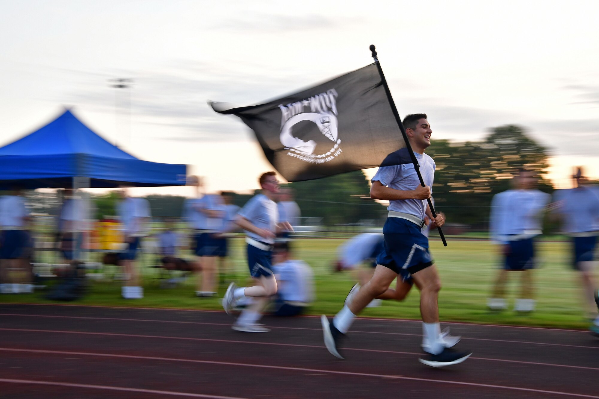 Airmen run on the track during a POW/MIA event.