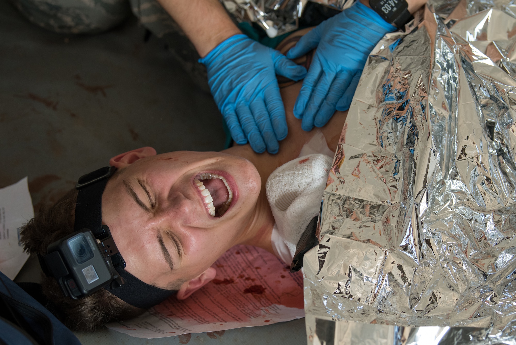 Airman 1st Class Dustin Stainback, 551st Special Operations Squadron special missions aviator, yells out in pain due to a knife in his shoulder during a scenario at the 2019 Medic Rodeo at Cannon Air Force Base, N.M., Sept. 18, 2019. The Medic Rodeo is designed to test the skills of air force medical technicians in both deployed and home installation environments. (U.S. Air Force photo by Staff Sgt. Michael Washburn)