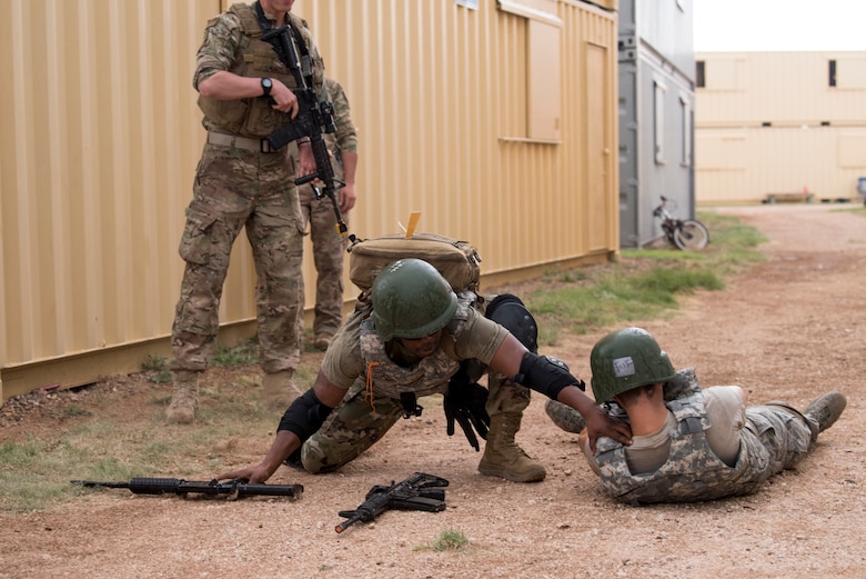 A medical technician reaches to help his fallen comrade during a scenario at the 2019 Medical Rodeo at Melrose Air Force Range, N.M., Sept. 19, 2019. The Medic Rodeo is designed to test the skills of air force medical technicians in both deployed and home installation environments. (U.S. Air Force photo by Staff Sgt. Michael Washburn)