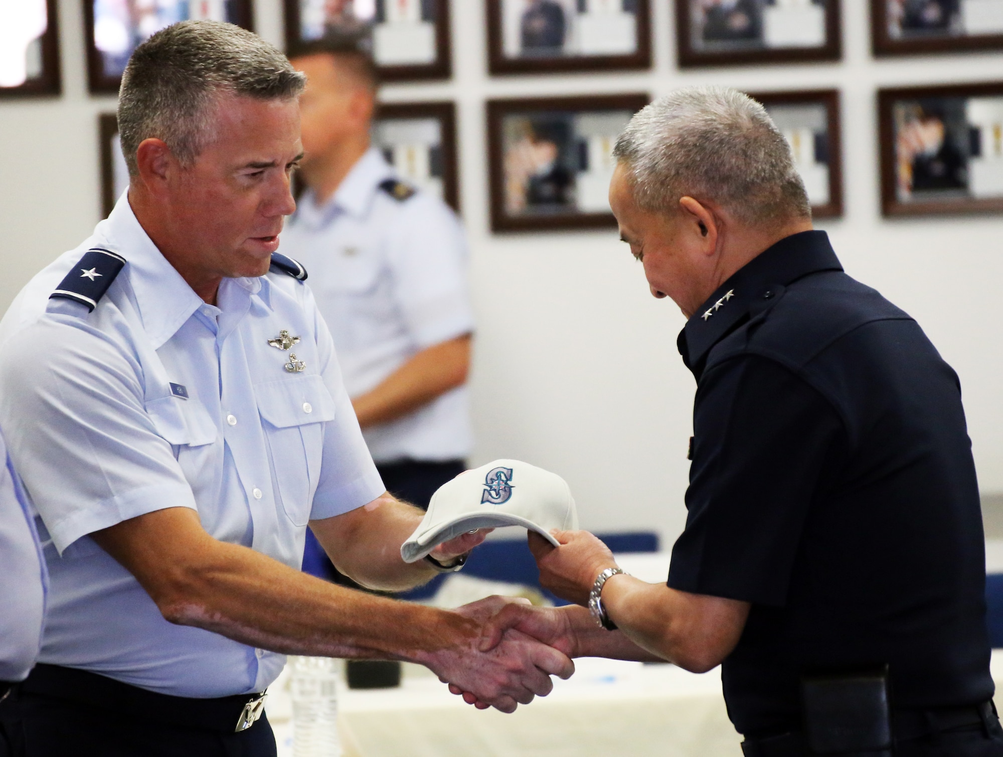 U.S. Air Force Brig. Gen. Jeremy Horn, Washington Air National Guard commander, presents Air Marshal Tarin Punsri, Royal Thai air force, a Seattle Mariners hat following the closing ceremonies of the sixth Airman-to-Airman talks at Camp Murray, Wash., August 28, 2019. A2A talks are jointly held conferences between PACAF and regional partner air forces designed to bring together both air forces to discuss and improve on training, tactics and procedures. This year marked the first talks to include participation by the Washington National Guard, with Washington state as the state partner to Thailand since 2002. (U.S. National Guard photo by Joseph Siemandel)