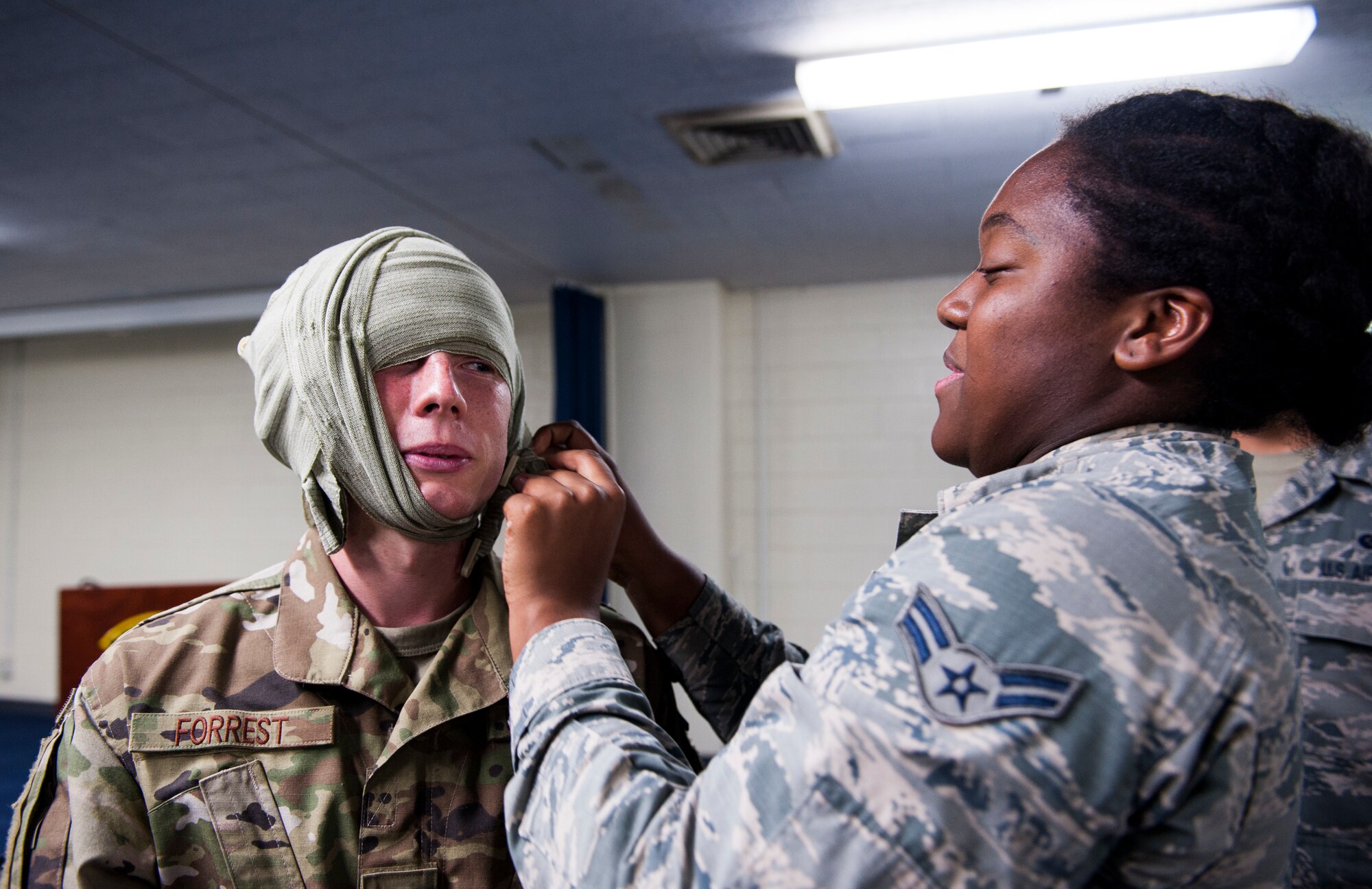 An Airman practices bandaging during Ability to Survive and Operate training at Kadena Air Base, Japan, Sept. 12, 2019. The ATSO training tested Airmen with various emergency situations including chemical attacks, unexploded ordnance and Self-Aid and Buddy Care. (U.S. Air Force photo by Naoto Anazawa)