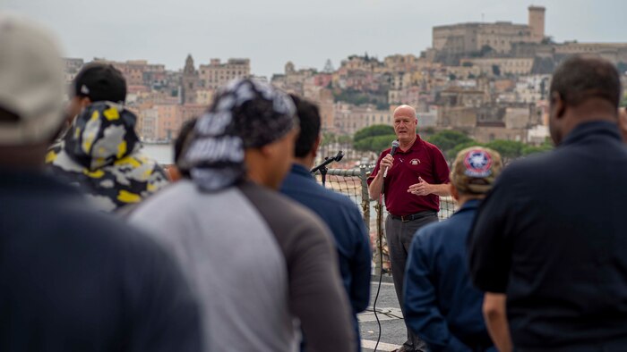 Christopher Thayer, MSC director, ship management, speaks during an MSC all hands call aboard USS Mount Whitney.