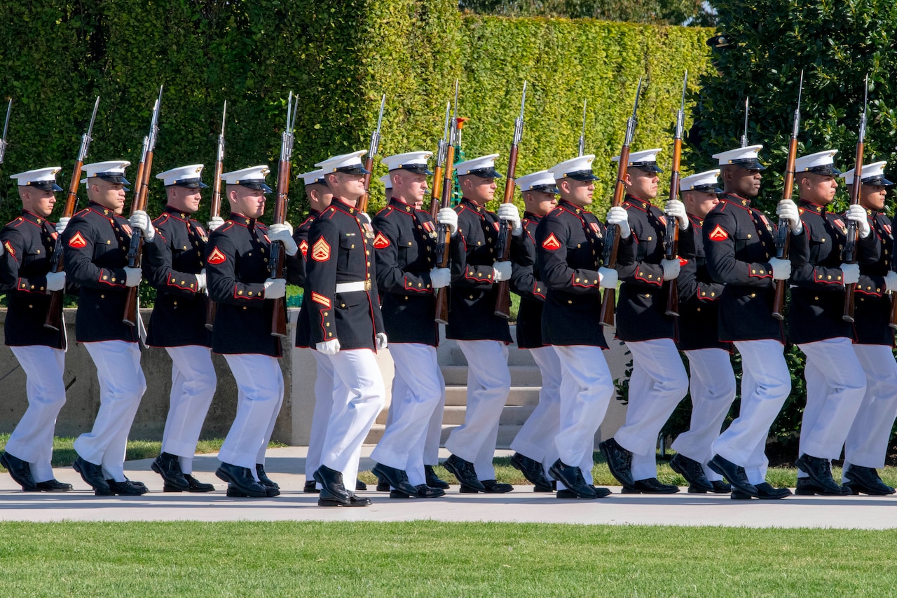 Uniformed personnel march together.