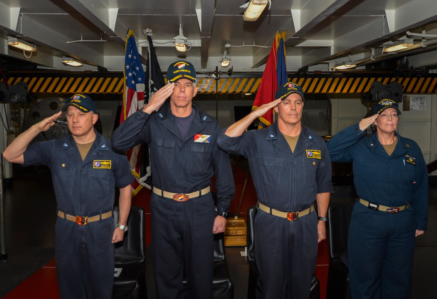 From left to right, Capt. Jon Duffy, off-going commander, Destroyer Squadron (DESRON) 15, Rear Adm. Karl O. Thomas, commander, Task Force 70, Capt. Steven DeMoss, on-coming commander, DESRON 15, and Cmdr. Jennifer Bowden, USS Ronald Reagan chaplain, salute during the national anthem during the DESRON 15 change of command ceremony aboard the aircraft carrier USS Ronald Reagan (CVN 76). DESRON 15 is the Navy's largest forward-deployed DESRON and the U.S. 7th Fleet's principal surface force.