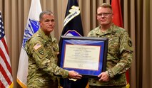 Lt. Gen. James Dickinson, left, commander of U.S. Army Space and Missile Defense Command, inducts Chief Warrant Officer 5 Wesley Klees as SMDC’s first command chief warrant officer during an investiture ceremony Sept. 12 at Peterson Air Force Base, Colorado. (U.S. Army photo by Dottie K. White)