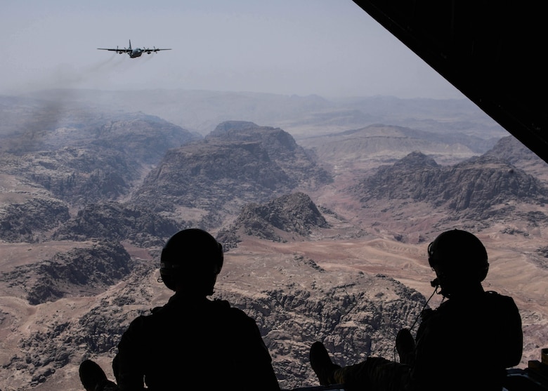 Two loadmasters from the 700th Airlift Squadron scan out of the rear of a C-130H3 while flying over the landscapes of Jordan during Exercise Eager Lion on Sept. 1, 2019.