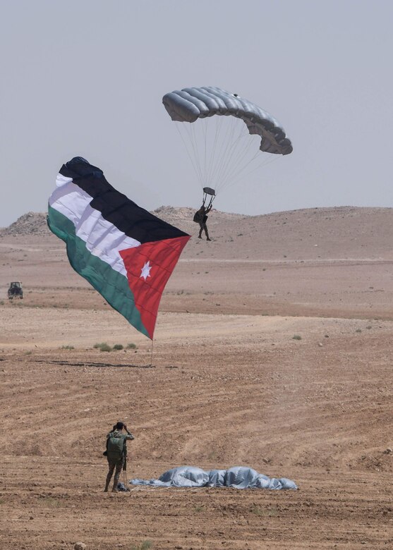 A participant of Exercise Eager Lion parachutes down with his native Jordanian flag from a static line jump during the Friendship Jump on Sept. 5, 2019 in Jordan.