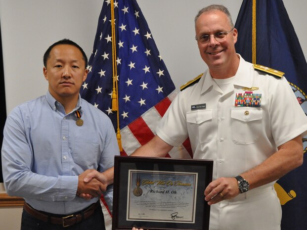 IMAGE: DAHLGREN, Va. (Aug. 30, 2019) – Naval Sea Systems Warfare Centers Commander Rear Adm. Eric Ver Hage presents the Secretary of Defense Medal for the Global War on Terrorism (GWOT) plaque to Richard Oh at an award ceremony moments after pinning GWOT Medal on Oh – a Naval Surface Warfare Center Dahlgren Division (NSWCDD) engineer. The GWOT Medal recognized and honored Oh’s contributions and accomplishments in direct support of the armed forces engaged in operations to combat terrorism.