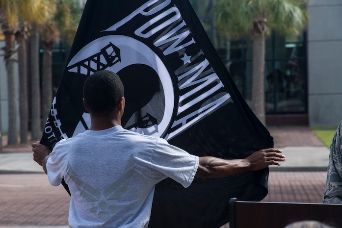 Senior Airman Joshua Hall, 437th Aerial Port Squadron cargo processing technician, adjusts the POW/MIA flag during a retreat ceremony Sep. 20, 2019, at Joint Base Charleston, S.C.