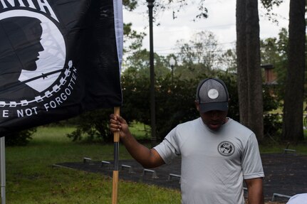 Master Sgt. Terrell Tilley, 628th Force Support Squadron career assistance advisor, holds the POW/MIA flag while a group gets ready to run during a memorial run Sep. 20, 2019, at Joint Base Charleston, S.C.