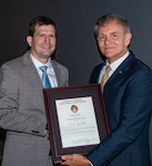 Dr. James “Tory” Cobb, distinguished scientist for advance signal processing and automation in mine warfare at Naval Surface Warfare Center Panama City Division, left, is presented with the National Defense Industrial Association (NDIA) Award for Technical Achievement in Undersea Warfare by Mike Cortese,division chair for the Undersea Warfare Division Sept. 17 in Groton, Connecticut.