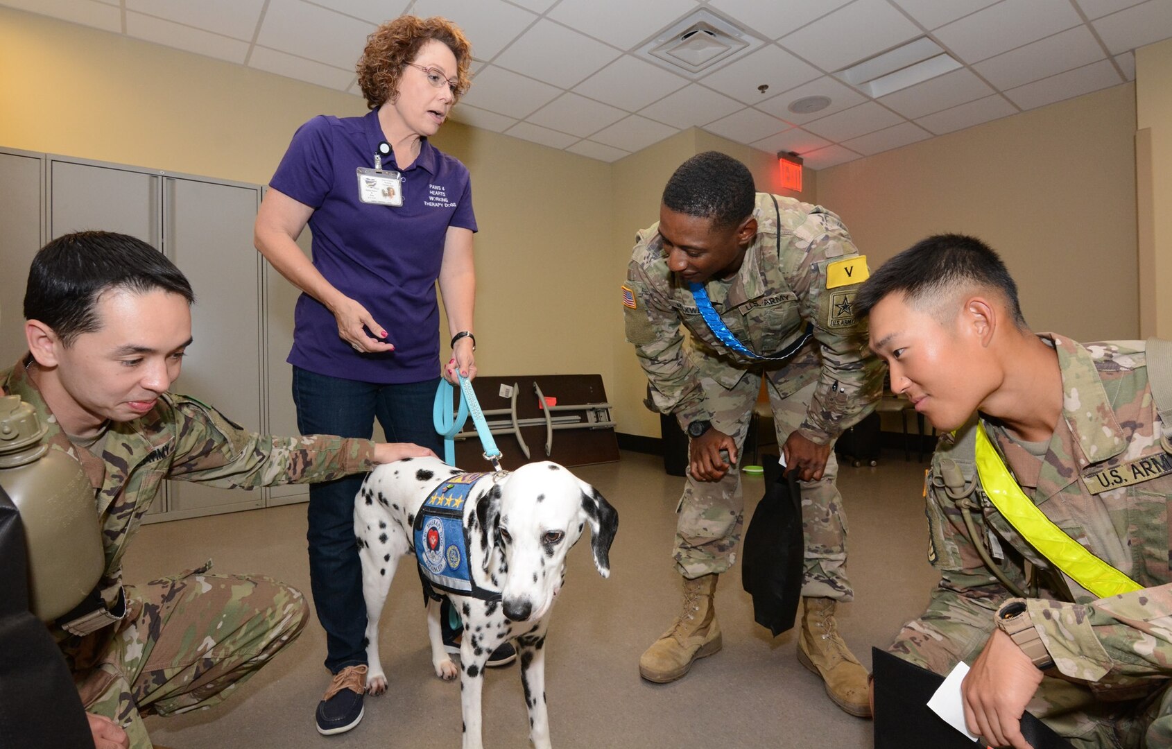 Soldiers pet a working therapy dog brought by volunteers with Paws 4 Hearts.