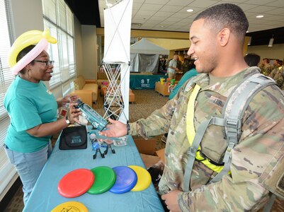 A Soldier answers a question about the Army SHARP program at the Frisbee booth.