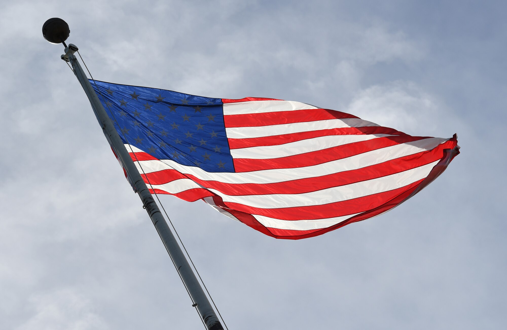 The U.S. Flag waves in the wind during the POW/MIA retreat ceremony at Keesler Air Force Base, Mississippi, Sept. 20, 2019. The event was held to raise awareness and to pay tribute to all prisoners of war and those military members still missing in action. (U.S. Air Force photo by Kemberly Groue)