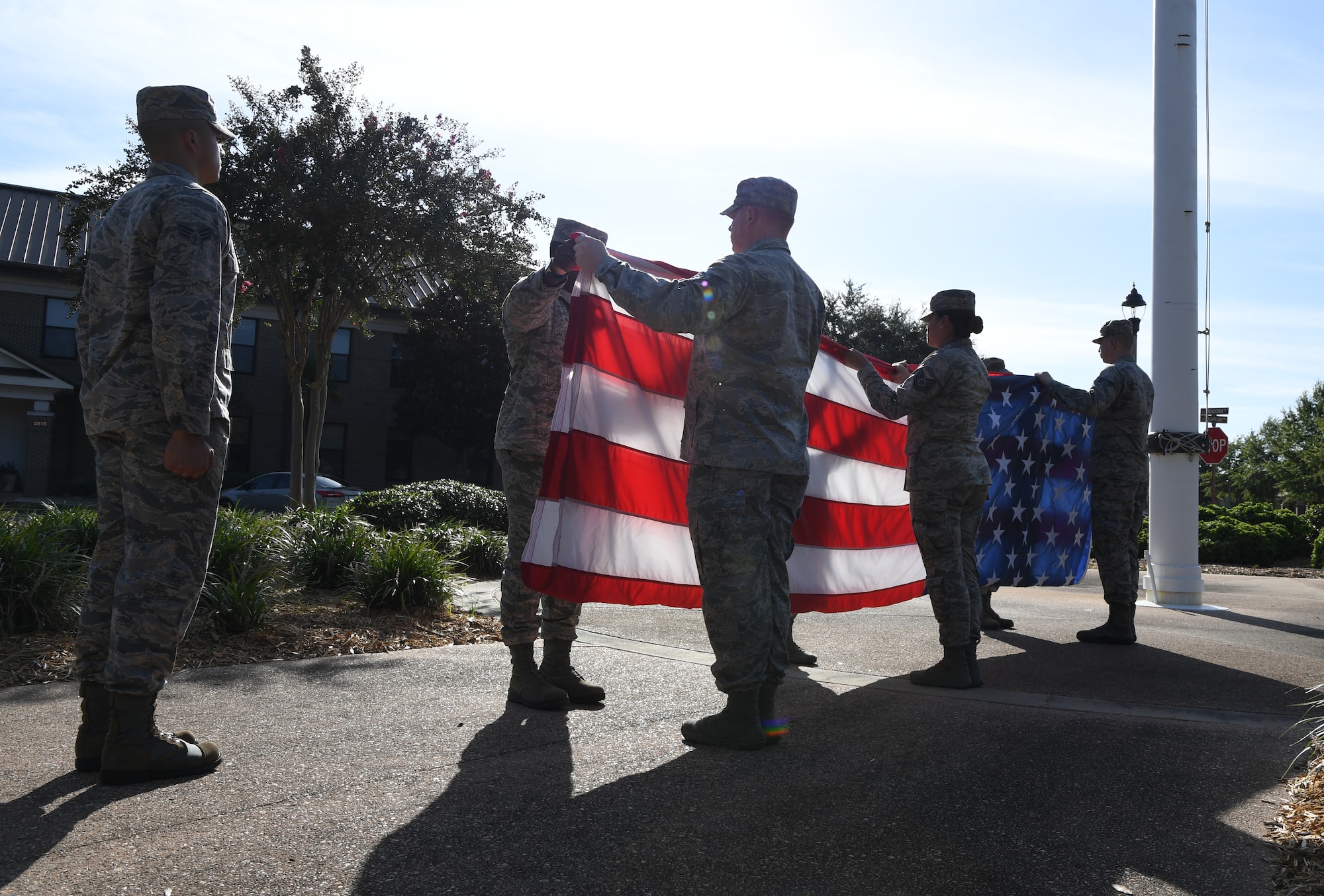 Keesler Airmen participate in folding the U.S. Flag during the POW/MIA retreat ceremony at Keesler Air Force Base, Mississippi, Sept. 20, 2019. The event was held to raise awareness and to pay tribute to all prisoners of war and those military members still missing in action. (U.S. Air Force photo by Kemberly Groue)