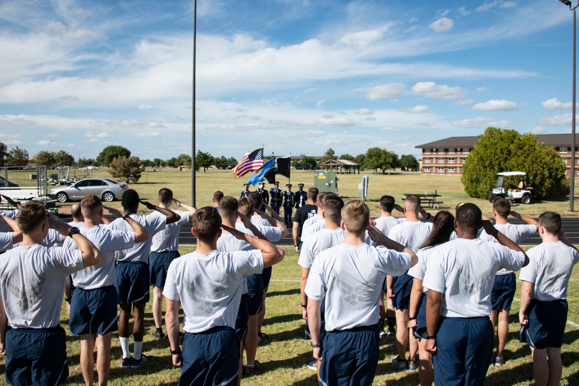 U.S. Air Force students of the 97th Training Squadron salute during reveille for the start of the 24-hour POW/MIA remembrance run