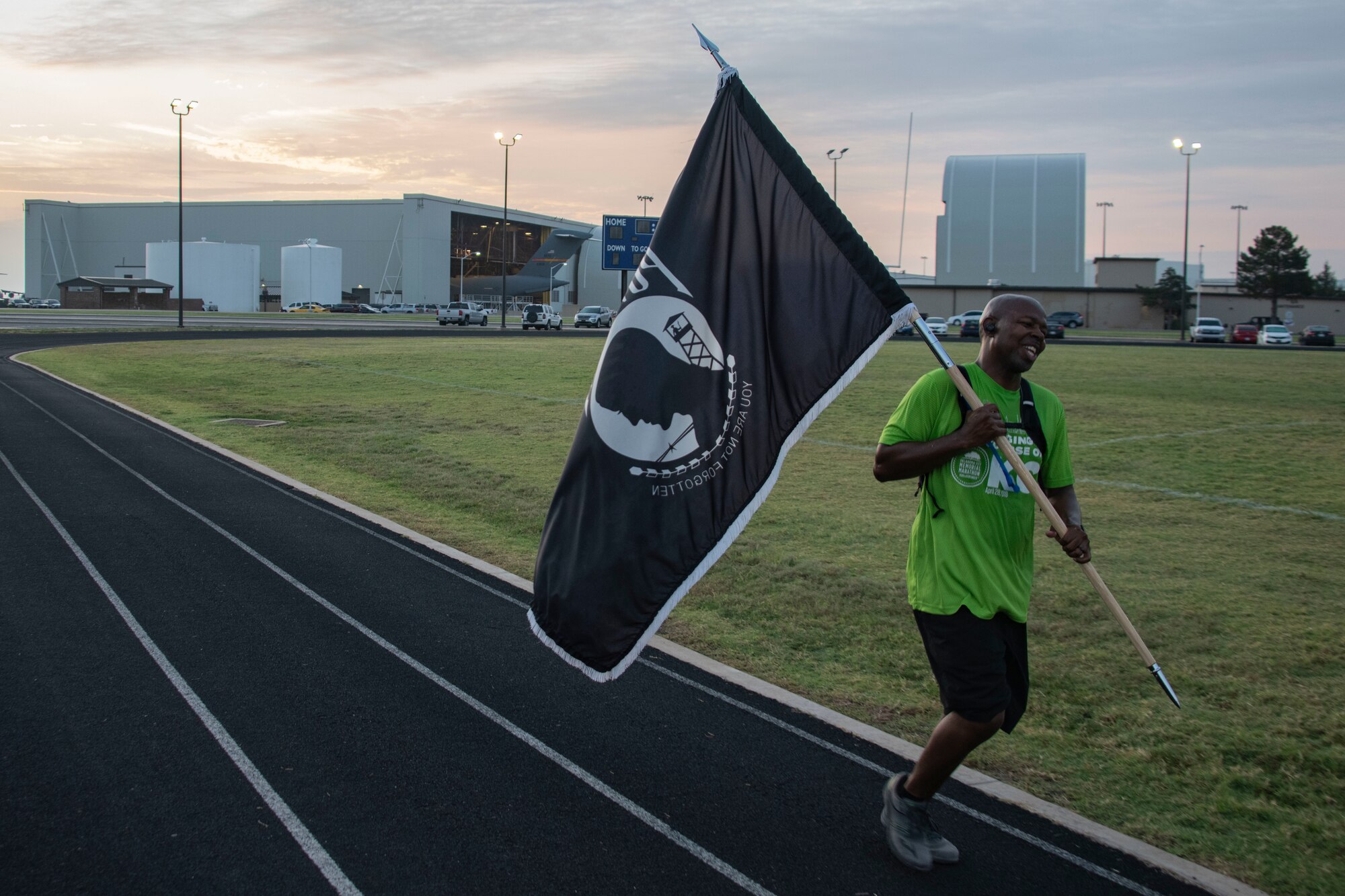 U.S. Air Force Senior Master Sgt. Zarcariaous Presha, 97th Operational Medical Readiness Squadron superintendent, carries the POW/MIA flag at the start of next duty day, during the 24-hour POW/MIA remembrance run